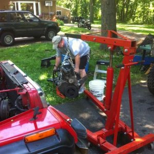 Dad with the motor from his Olive drab XJ. You can barely see his tire on the far right, Pulled his motor and swapped it in my YJ.